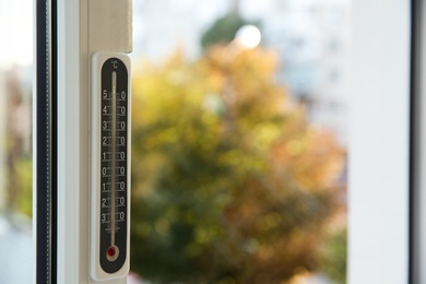 Photo of Weather thermometer on window frame indoors. Space for text