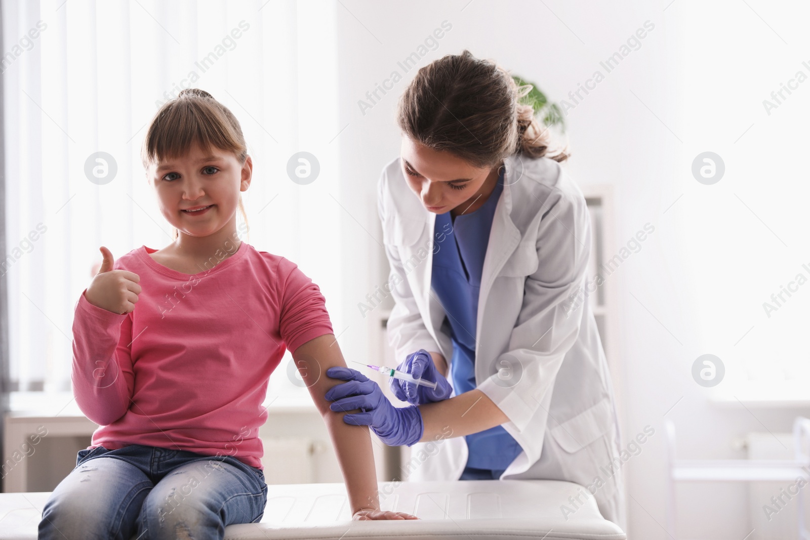 Photo of Little girl receiving chickenpox vaccination in clinic. Varicella virus prevention