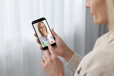 Online medical consultation. Woman having video chat with doctor via smartphone at home, closeup