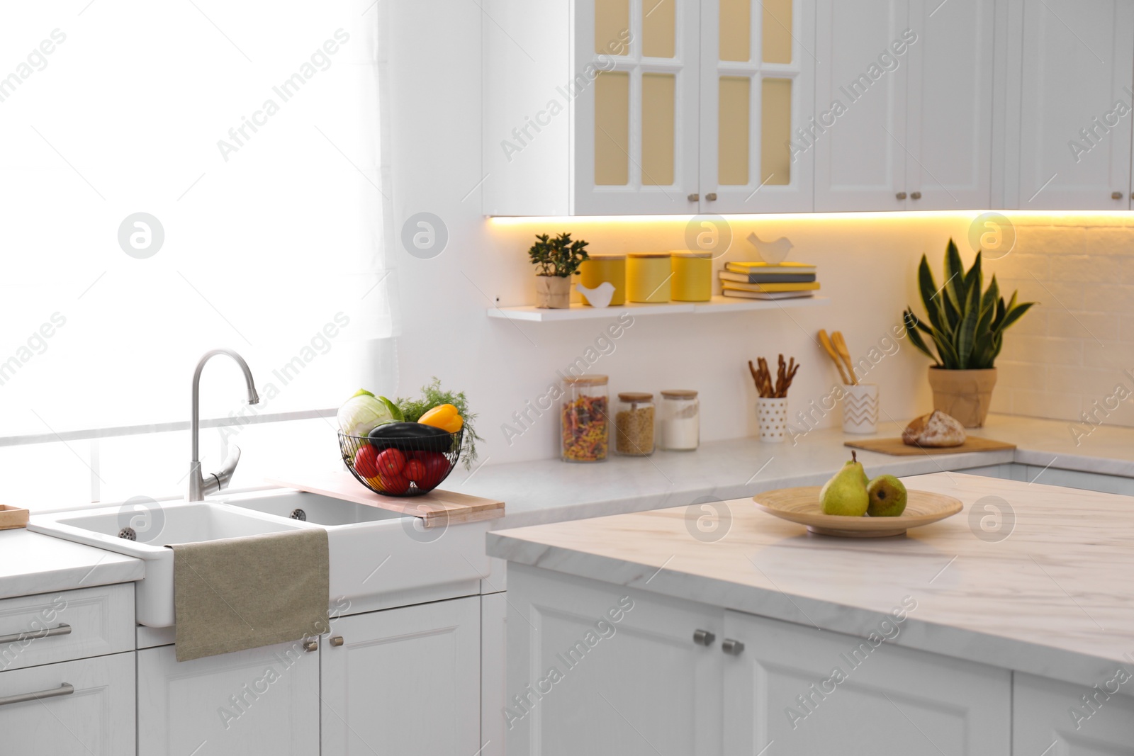 Photo of Modern kitchen interior with different products on counter and table