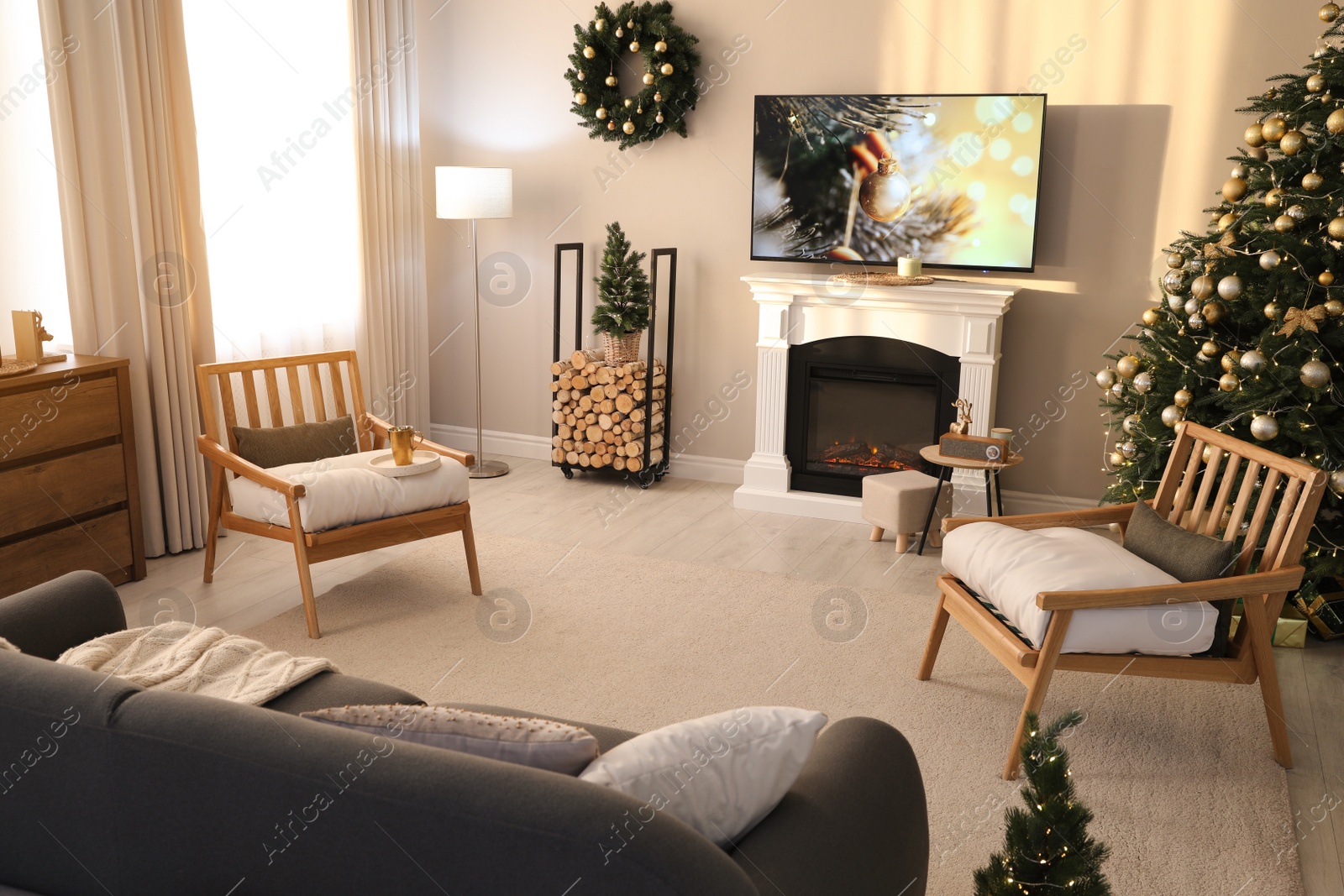 Photo of Modern TV set on light wall in room decorated for Christmas