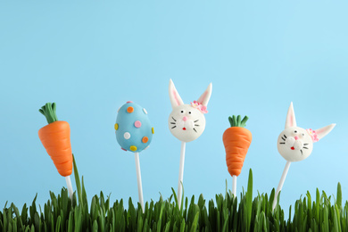 Photo of Different delicious sweet cake pops on light blue background. Easter holiday