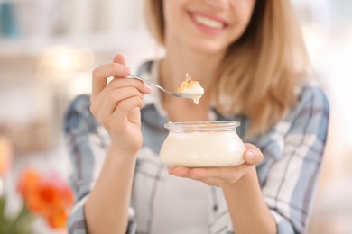 Young woman eating tasty yogurt, closeup