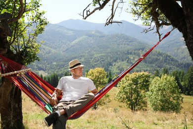 Man resting in hammock outdoors on sunny day