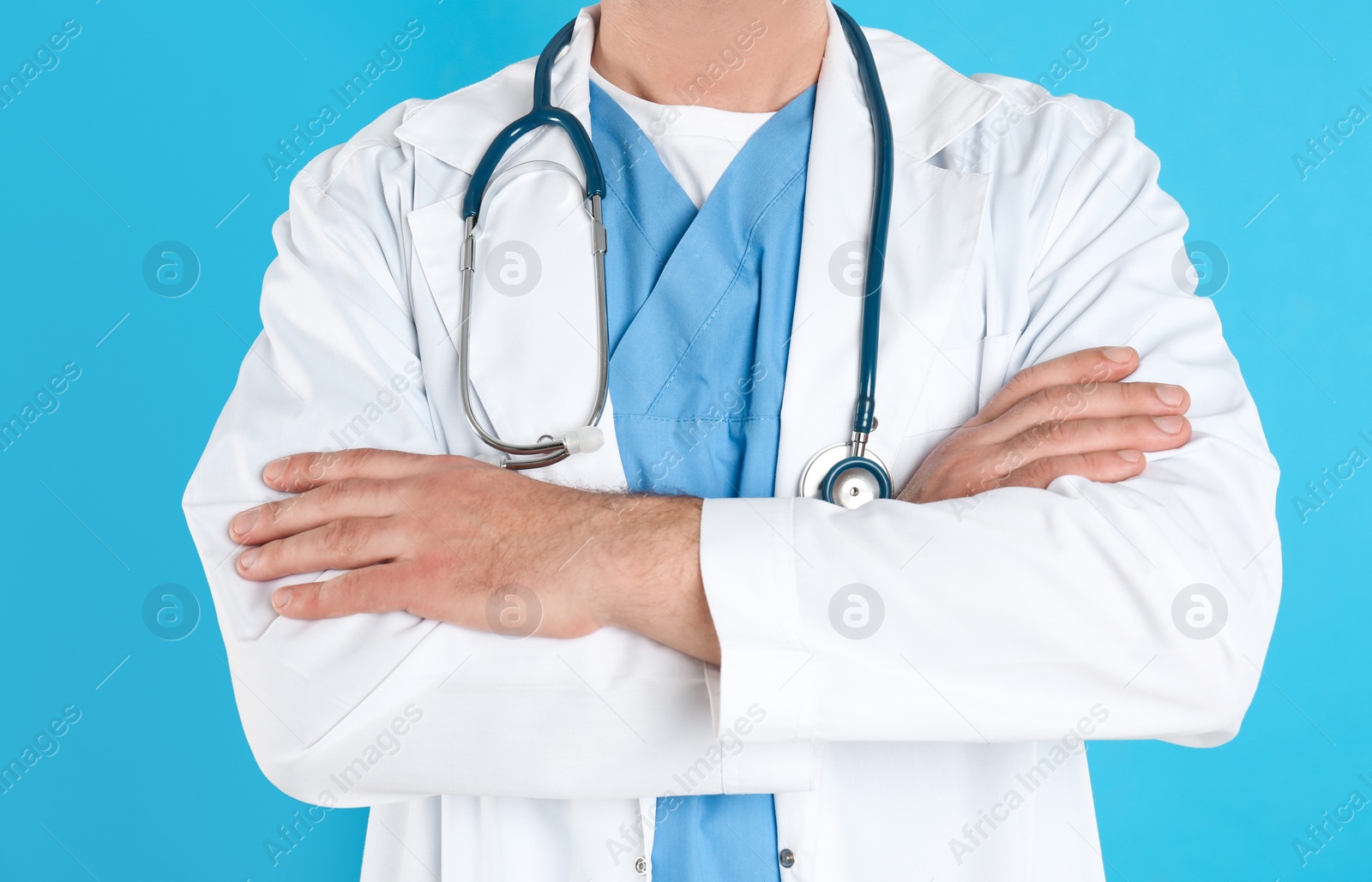 Photo of Mature doctor with stethoscope on blue background, closeup