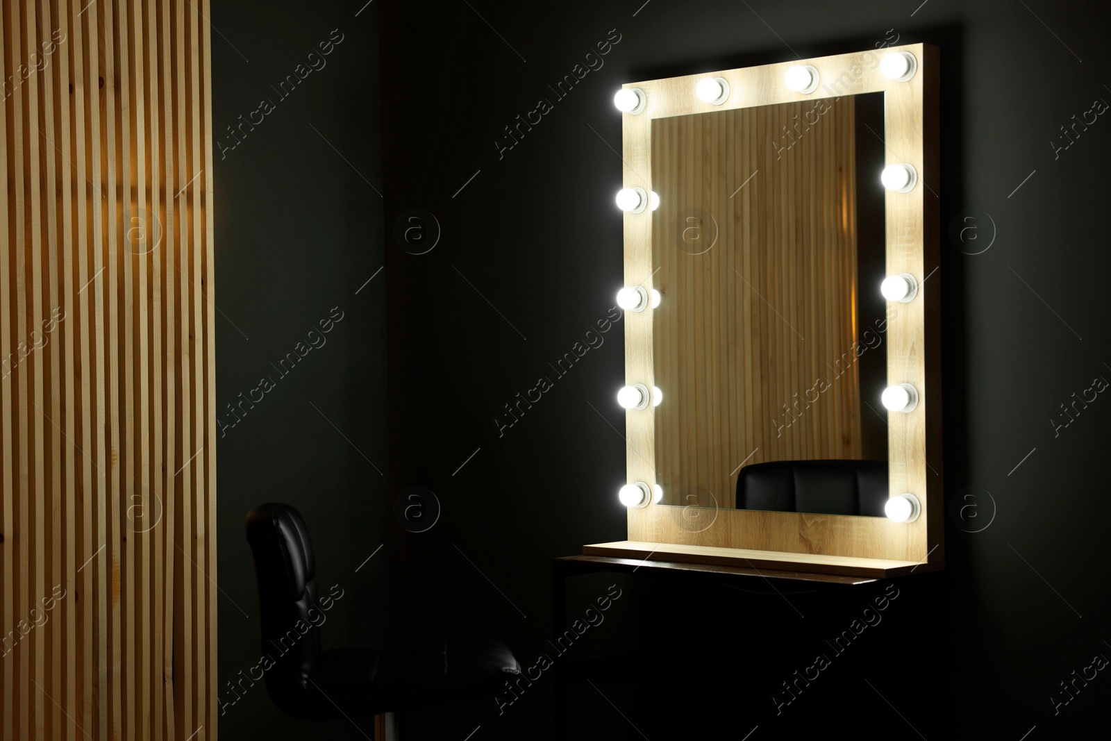 Photo of Beautiful mirror with light bulbs and chair in makeup room