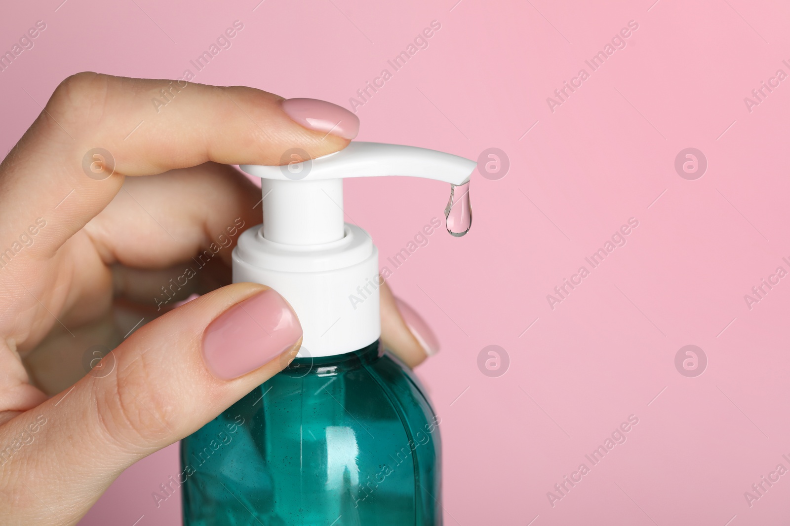 Photo of Woman using cleansing gel on pink background, closeup. Space for text