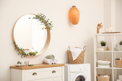 Round mirror on white wall in modern bathroom