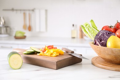 Different raw vegetables on white marble table in kitchen