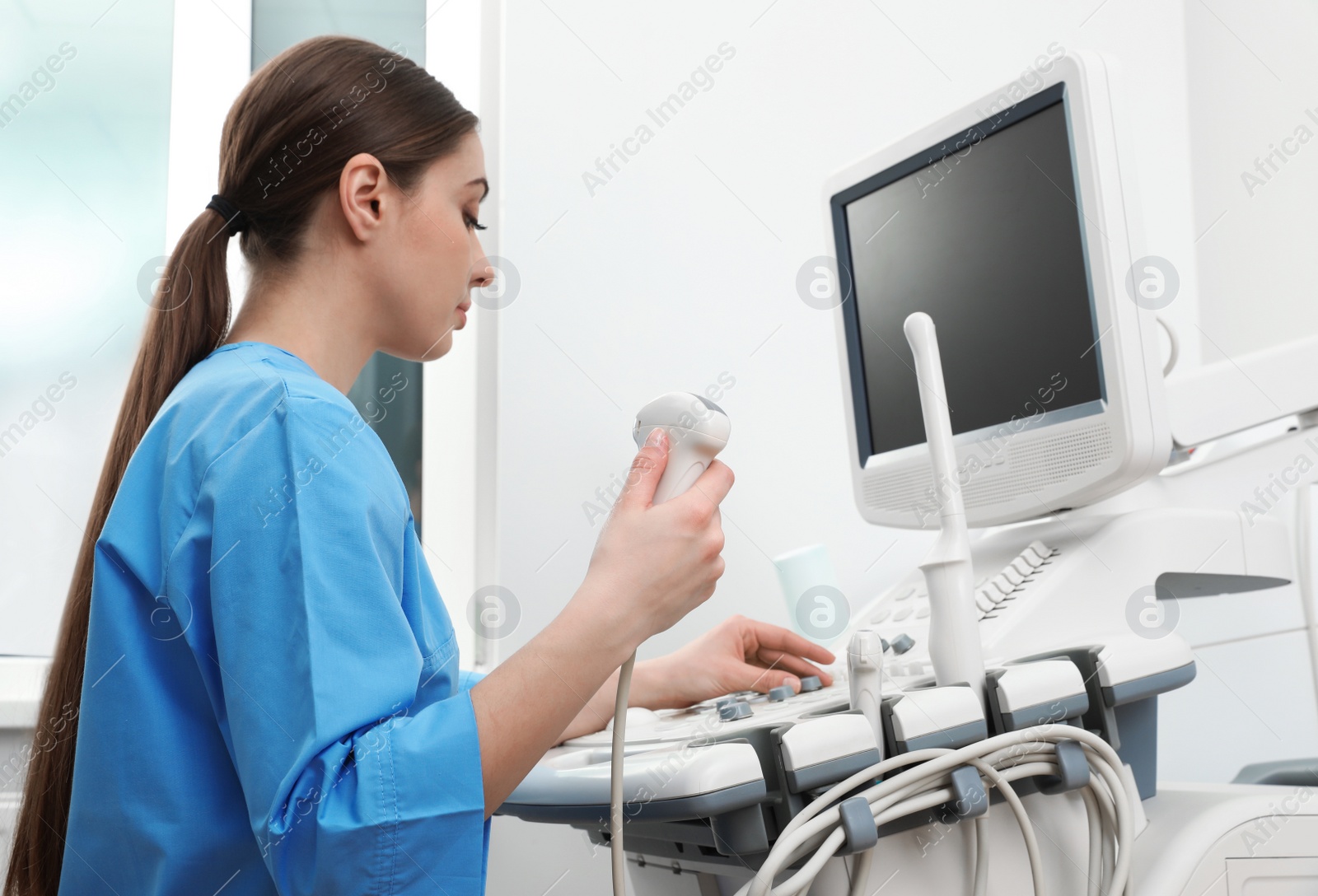 Photo of Sonographer operating modern ultrasound machine in clinic