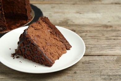 Piece of delicious chocolate truffle cake on wooden table, closeup