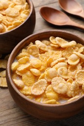 Photo of Tasty cornflakes with milk served on wooden table, closeup