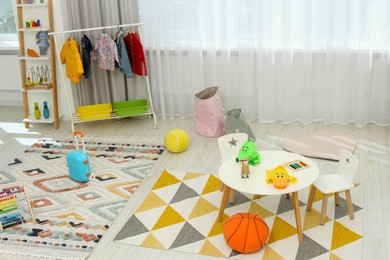 Child`s playroom with different toys and modern furniture. Stylish kindergarten interior