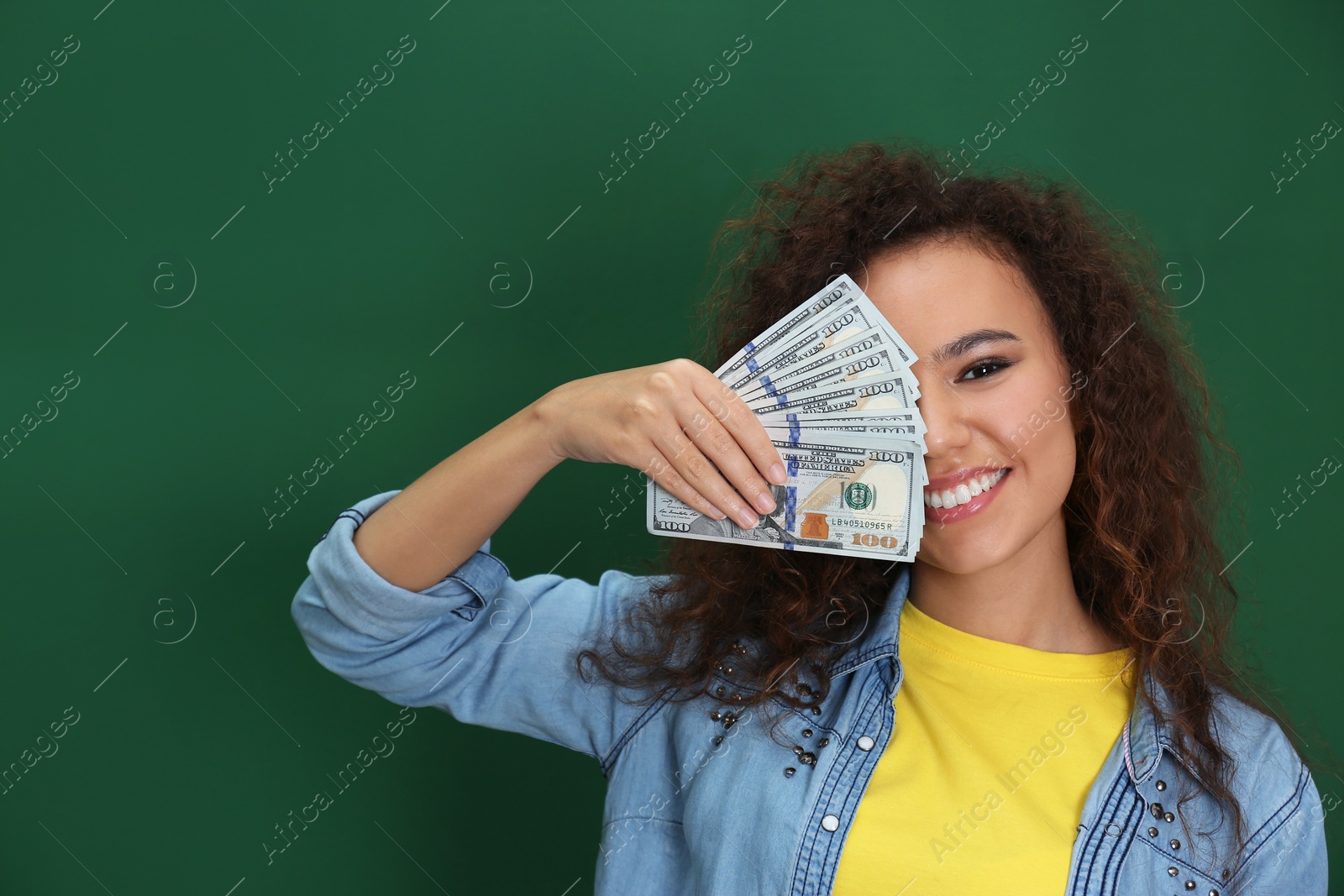 Photo of Young African-American woman with money on color background. Space for text