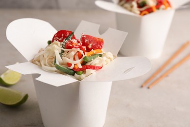 Photo of Box of vegetarian wok noodles on light table, closeup