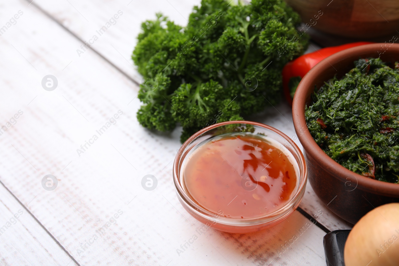 Photo of Fresh marinades and ingredients on white wooden table, space for text