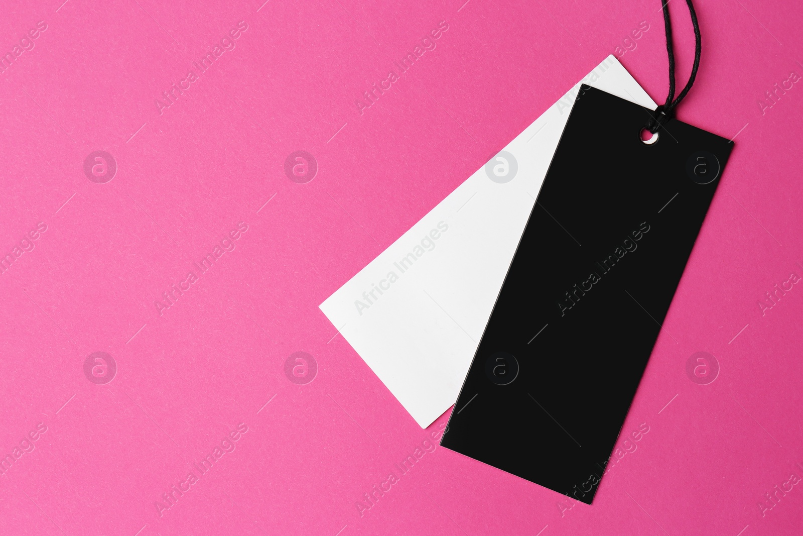 Photo of Tags with space for text on pink background, top view