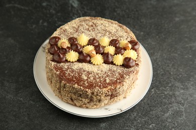 Delicious Kyiv Cake with cream and hazelnuts on black table