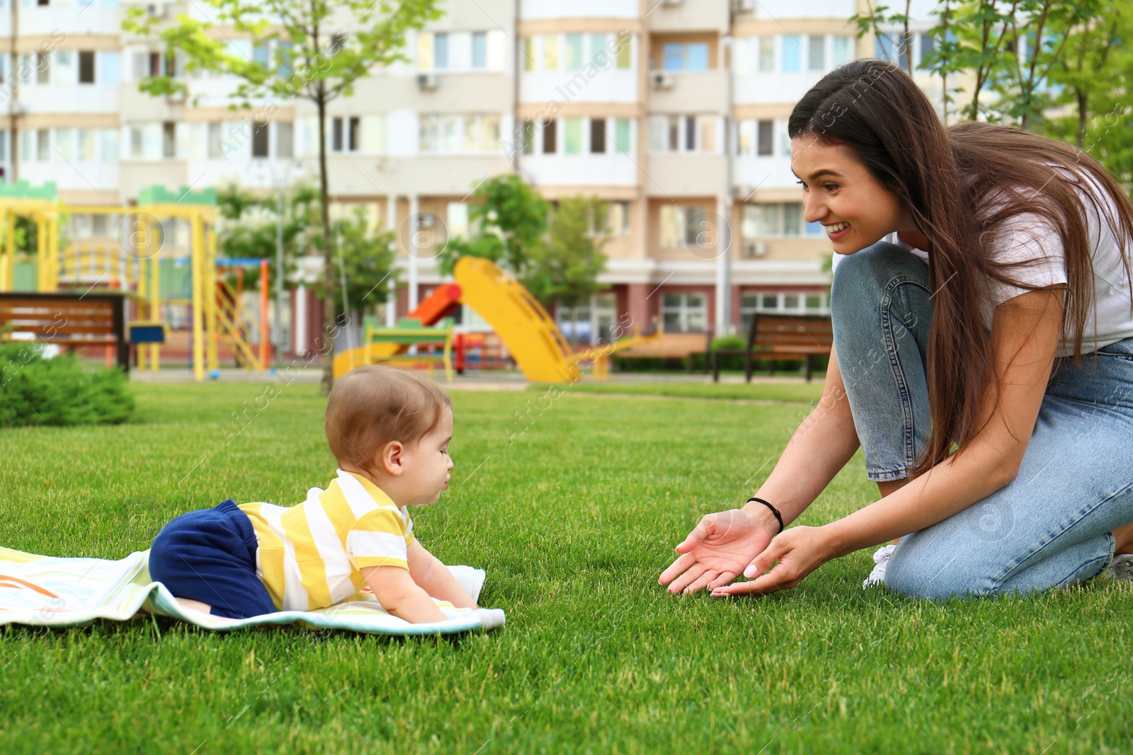 Photo of Adorable little baby crawling towards mother outdoors