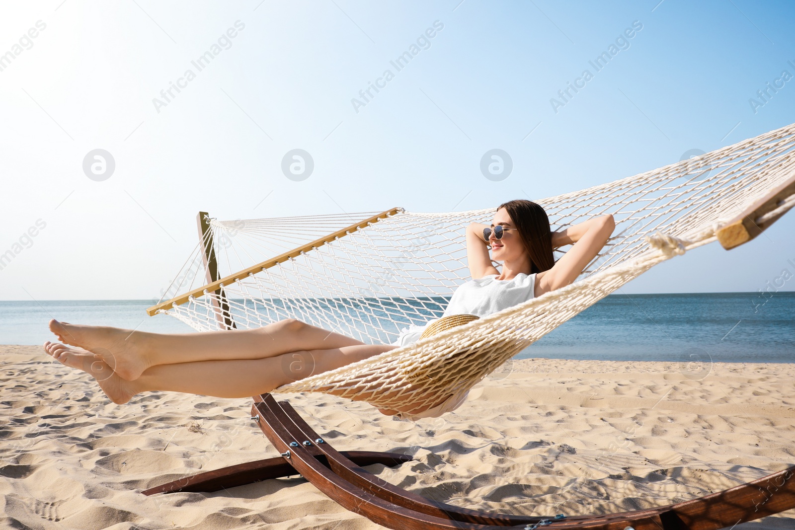 Photo of Young woman relaxing in hammock on beach