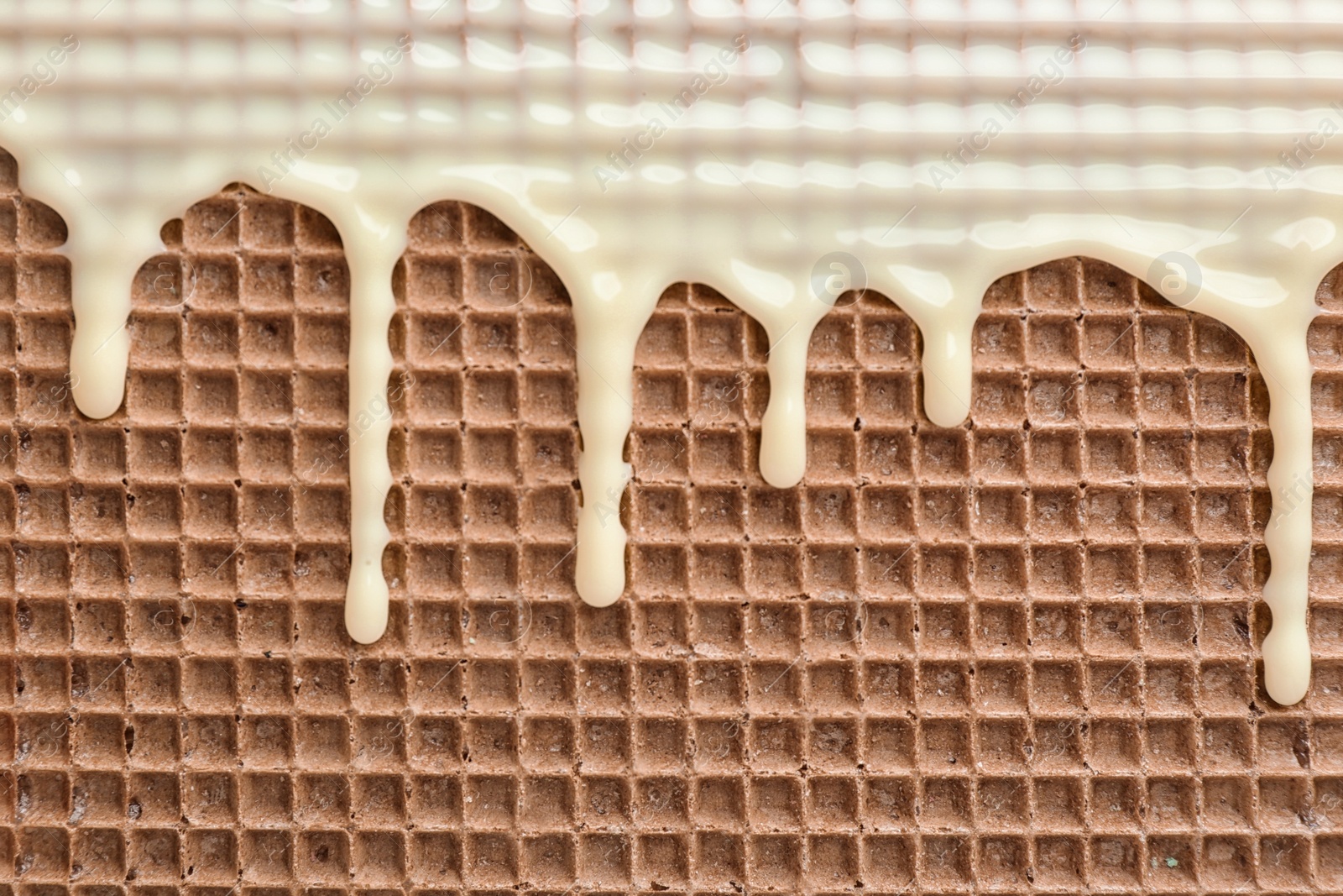 Photo of Hot white chocolate on wafer, closeup. Crispy food