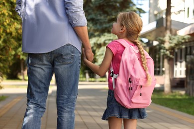 Photo of Little girl with her father on way to school