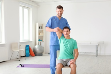 Physiotherapist working with male patient in clinic