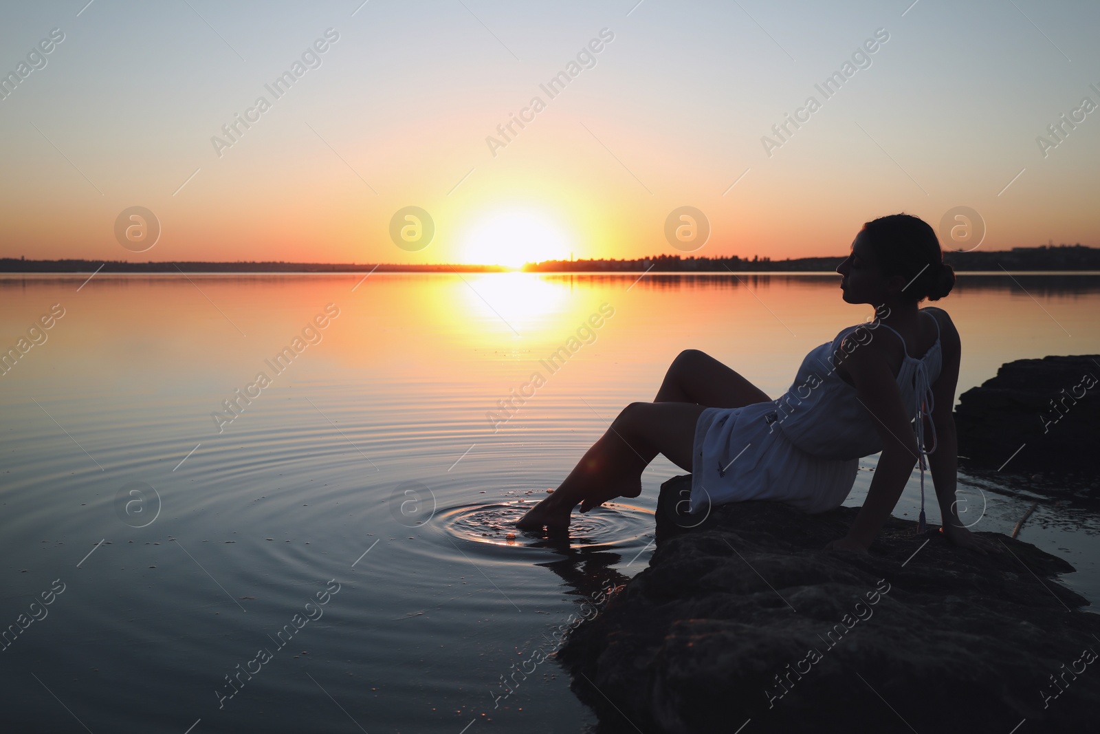 Photo of Woman near river on sunset. Healing concept