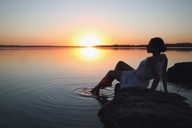 Woman near river on sunset. Healing concept