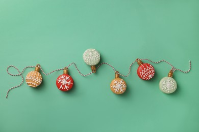Photo of Beautifully decorated Christmas macarons with rope on turquoise background, flat lay