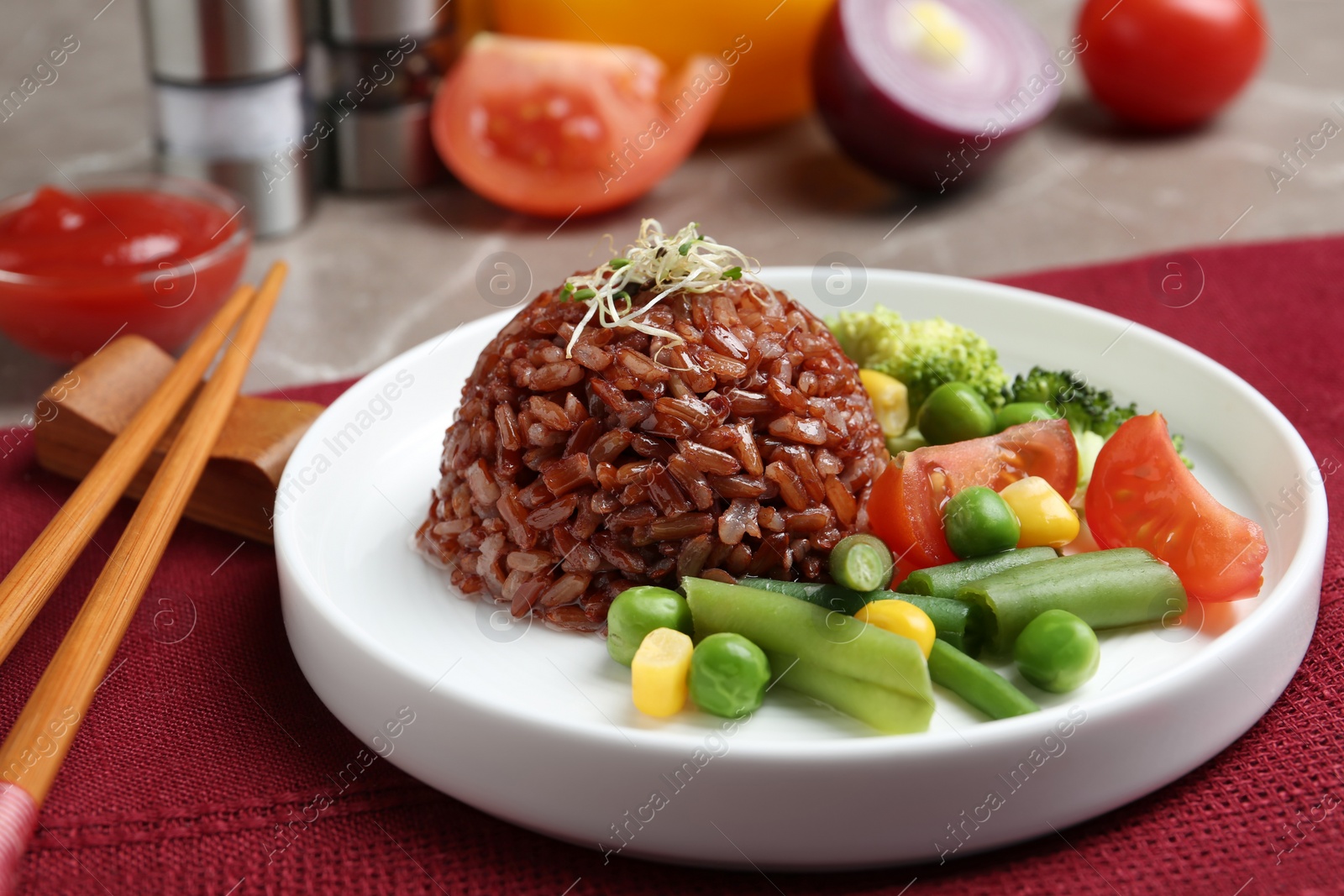 Photo of Plate of boiled brown rice with vegetables served on table