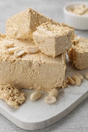 Pieces of tasty halva on light gray table, closeup