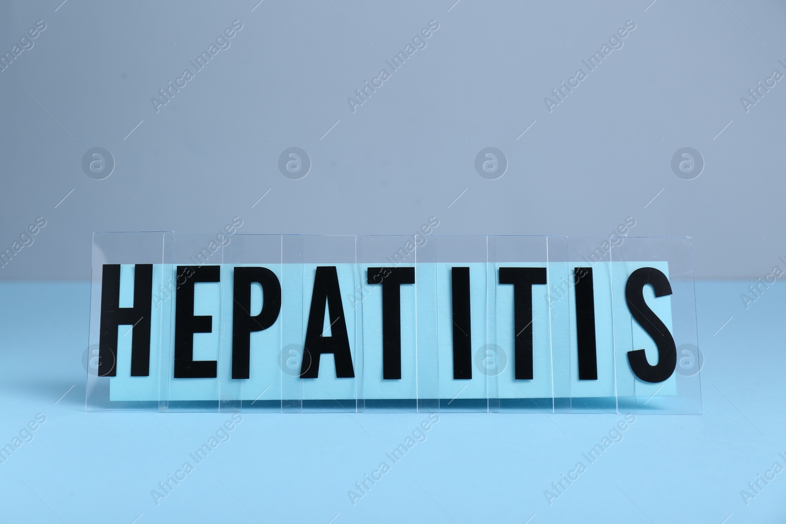 Photo of Word Hepatitis on light blue table. Medical issue