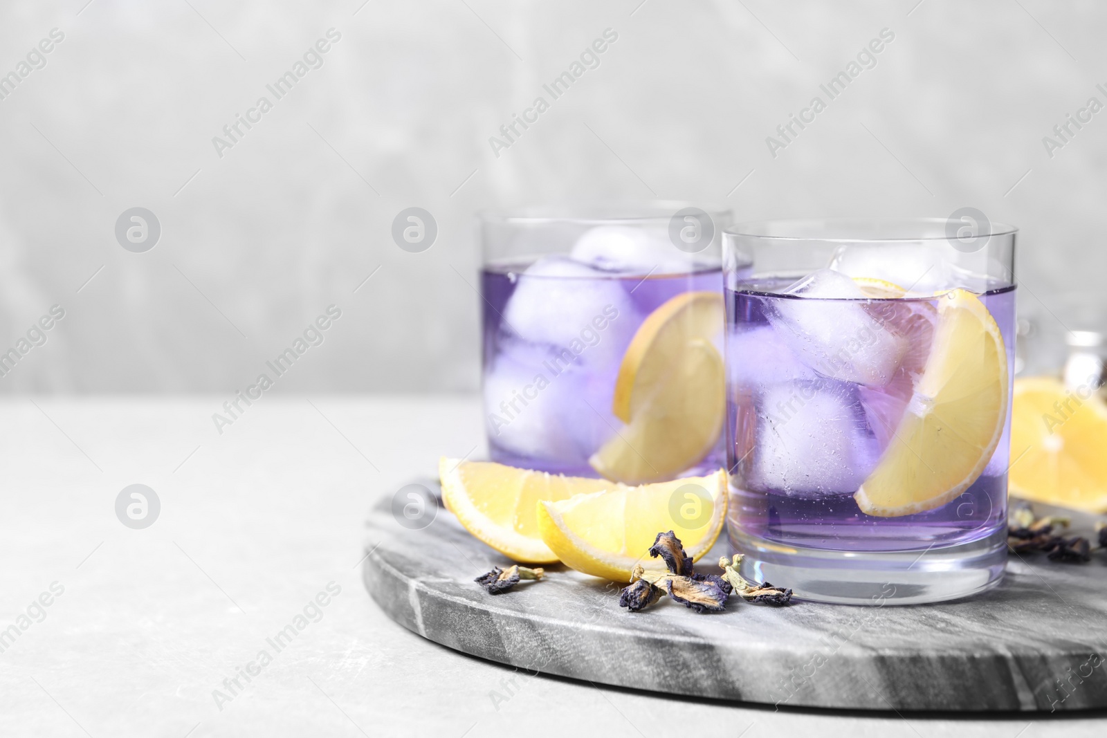 Photo of Organic blue Anchan with lemon on light table, space for text. Herbal tea