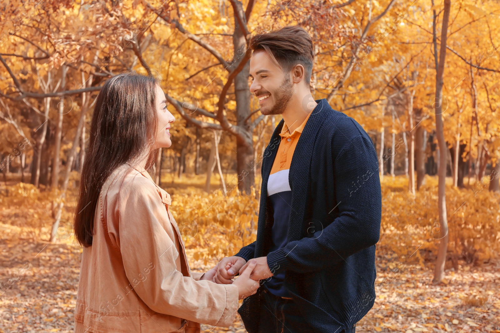 Photo of Young lovely couple spending time together in park. Autumn walk