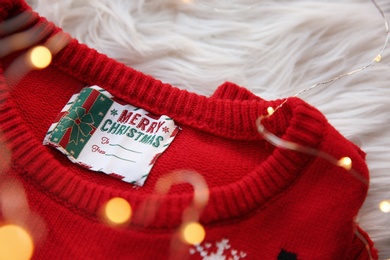 Photo of Christmas sweater with tag on fur, closeup