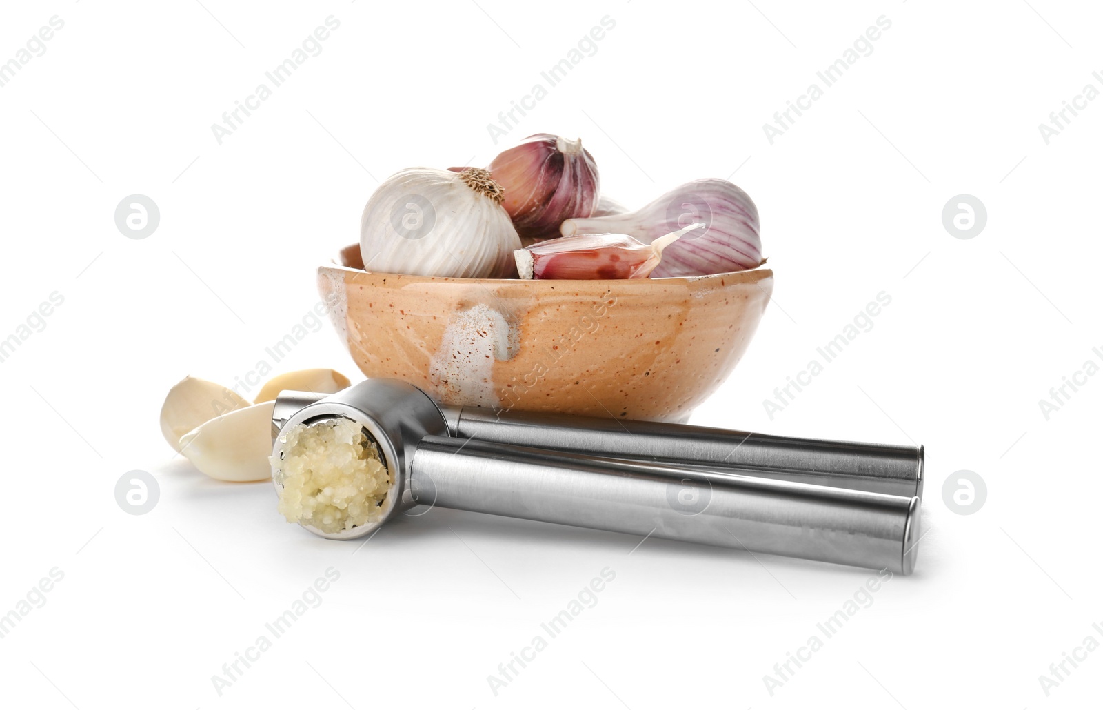 Photo of Garlic press and bowl with cloves on white background