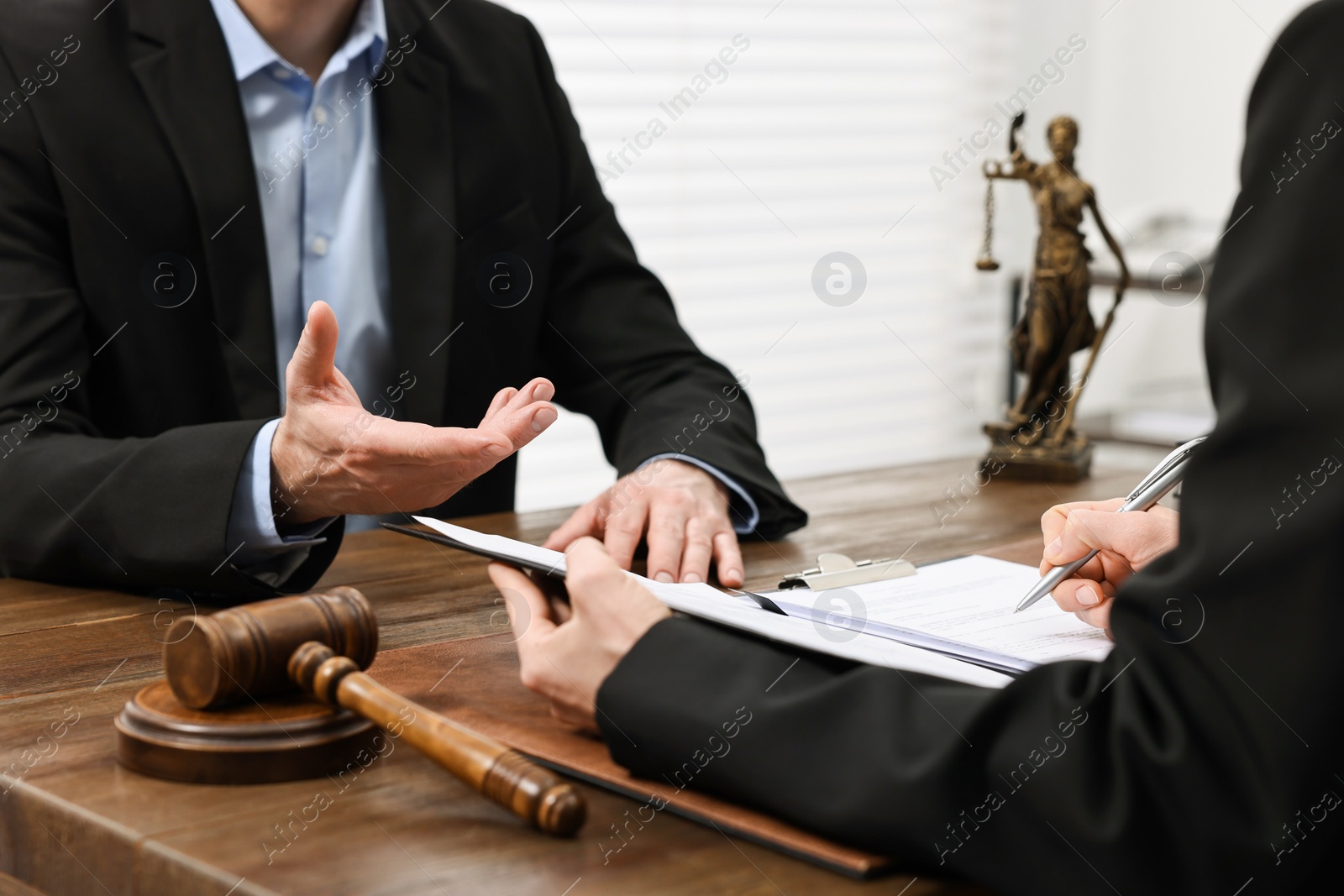 Photo of Woman signing document in lawyer's office, closeup