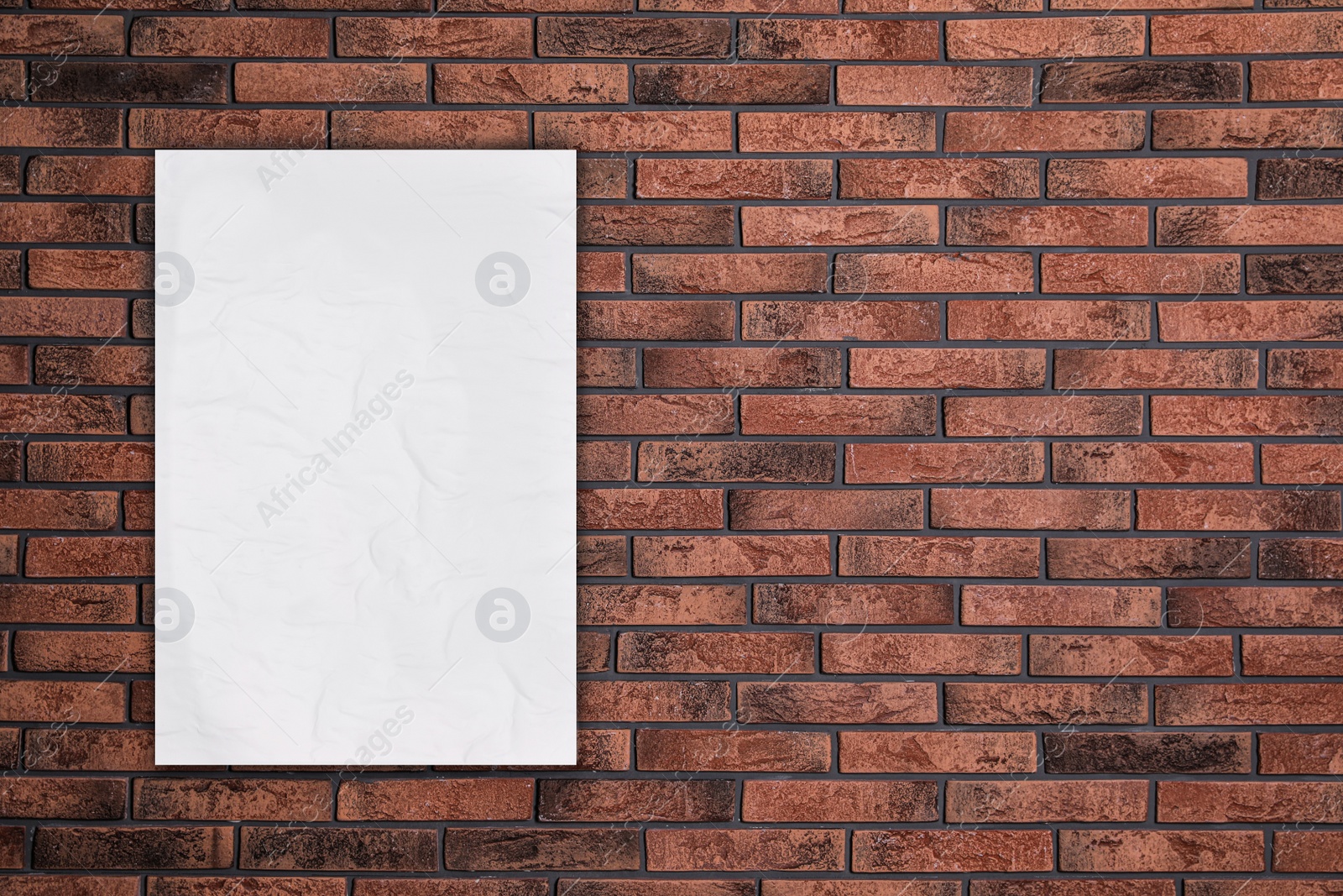 Image of Blank creased poster on brick wall. Mockup for design 