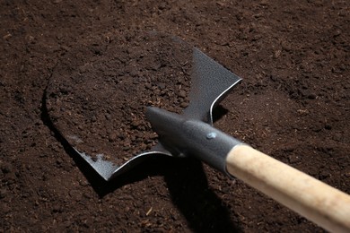 Photo of Metal shovel on fertile soil. Gardening tool