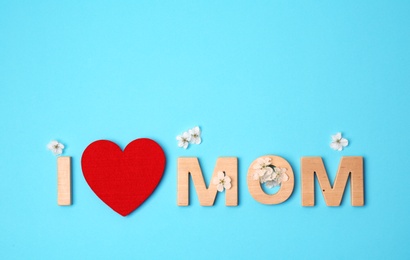 Phrase "I LOVE MOM" made of letters and red heart on color background. Happy Mother's Day