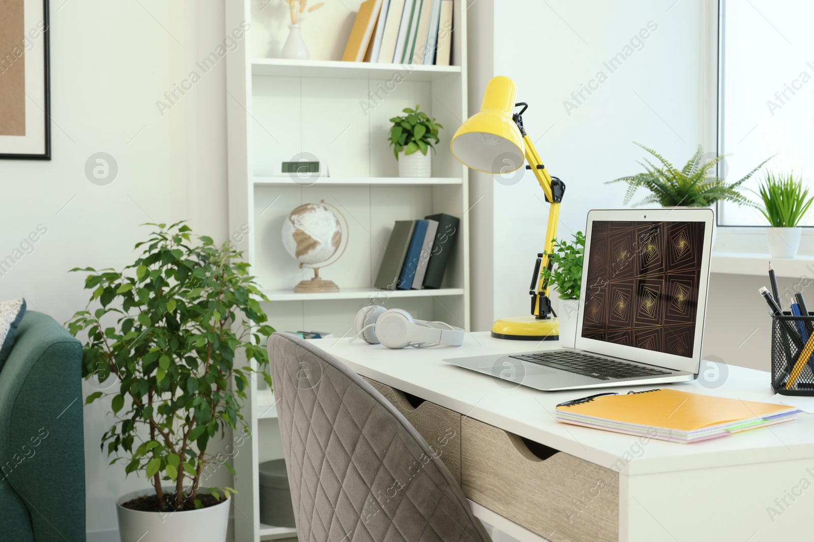 Photo of Cozy workspace with laptop on white wooden desk at home