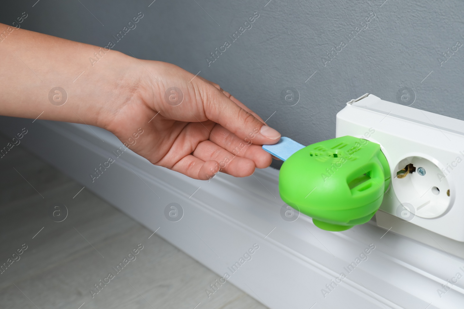 Photo of Woman putting insect repellent plate into electric mosquito device at home, closeup