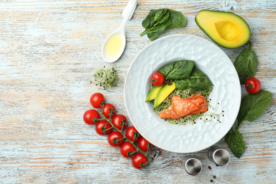 Photo of Delicious salmon with spinach served on light wooden table, flat lay