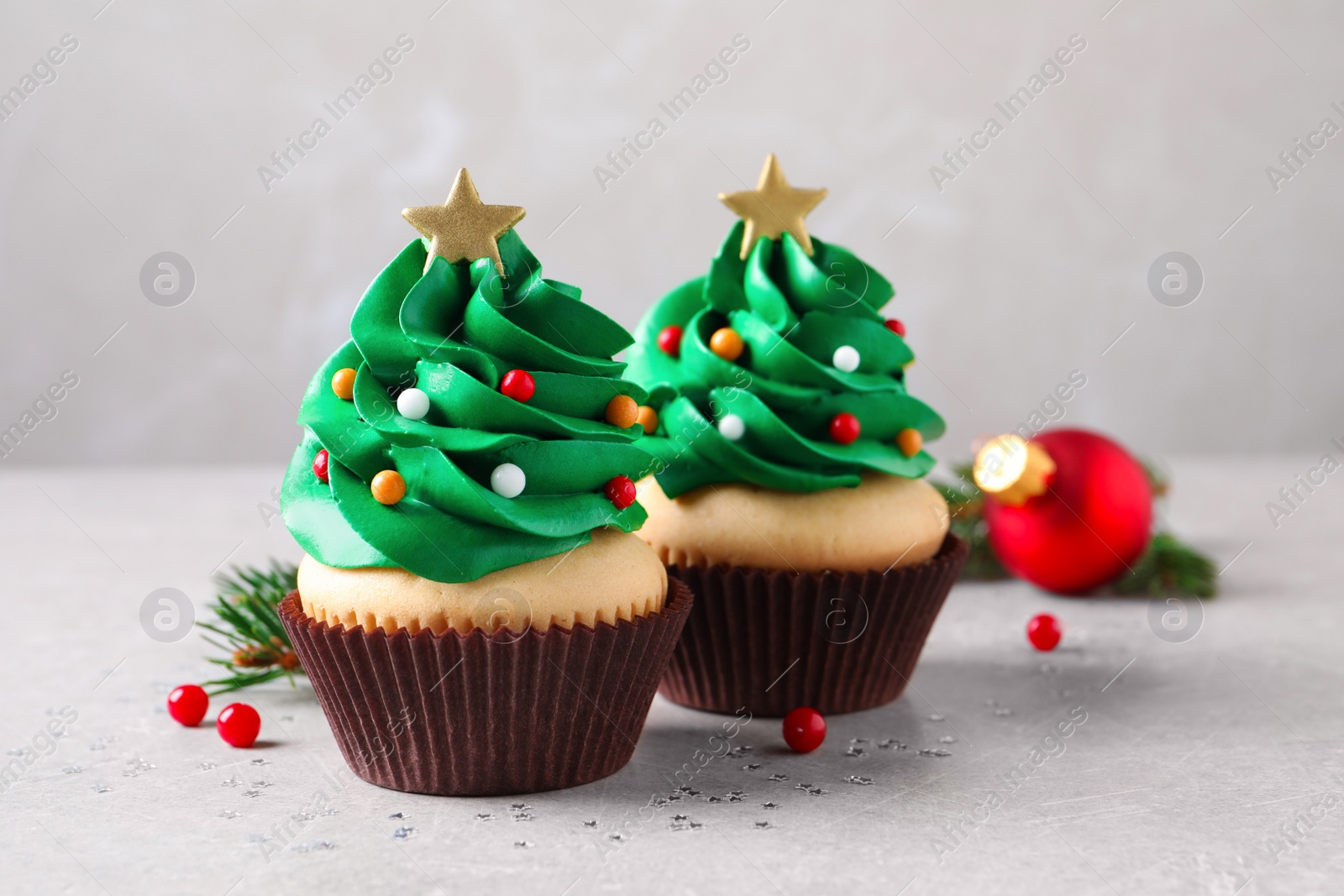 Photo of Christmas tree shaped cupcakes on light grey table