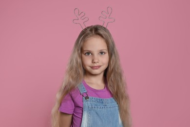 Girl wearing beautiful headband on pink background