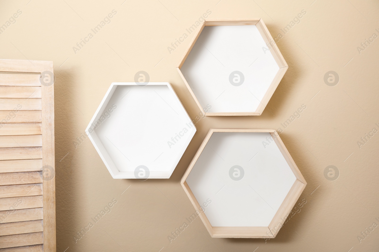 Photo of Empty honeycomb shaped shelves on beige wall