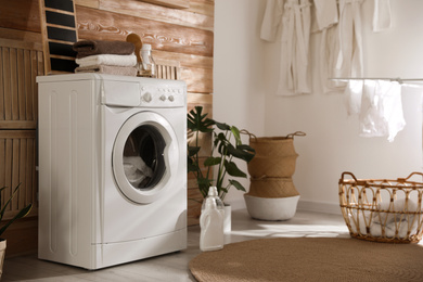 Photo of Stylish room interior with washing machine. Design idea