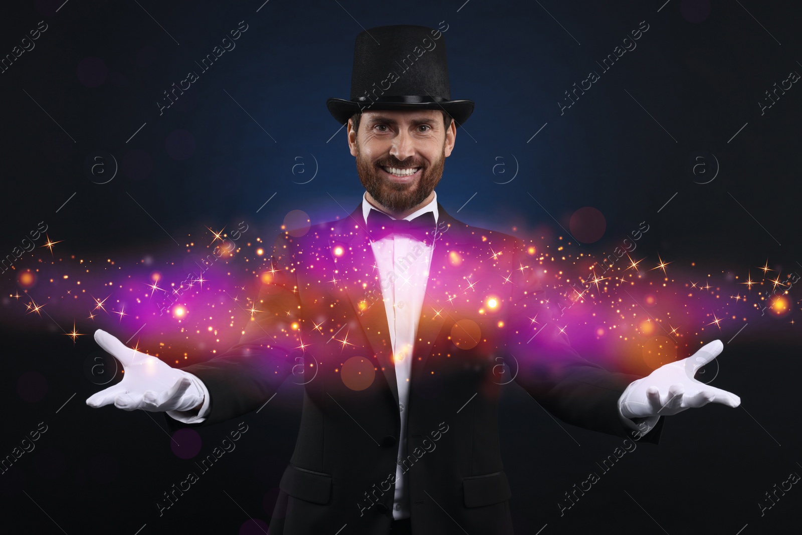 Image of Smiling magician showing trick on dark blue background