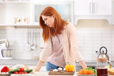 Tired housewife cooking in kitchen